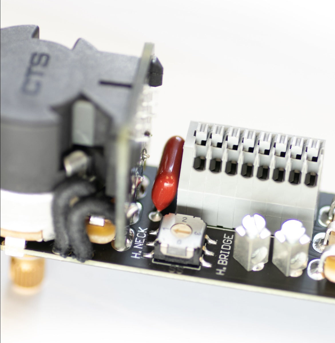 an ObsidianWire HH & HS Custom Universal Tele Wiring Harness is shown on a clear cut white background. The image is zoomed in in the small components of the harness.